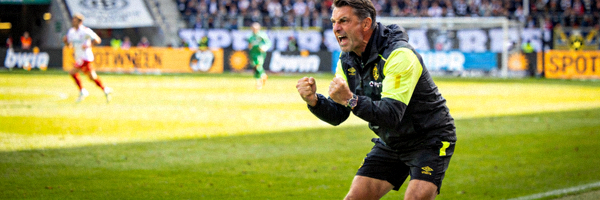 足球教练在场边指挥，表情严肃